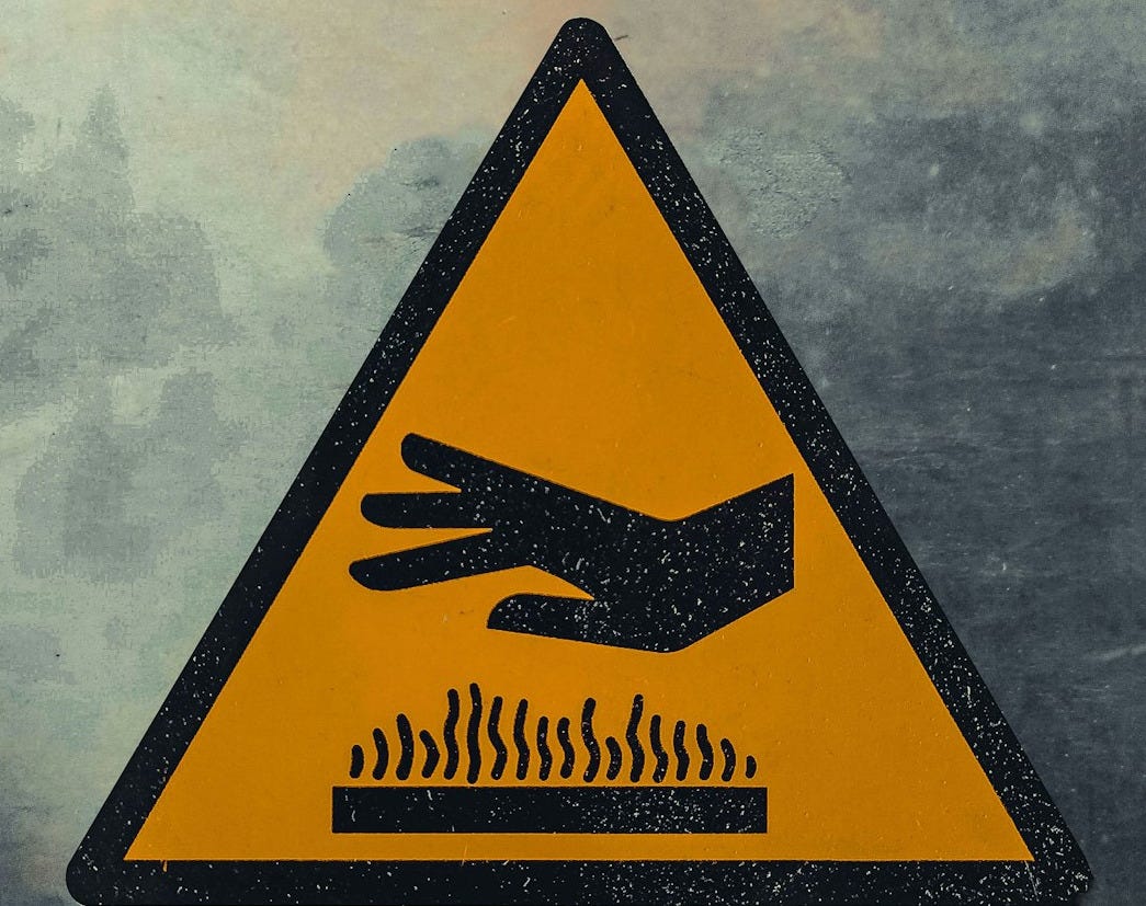 a yellow and black hazard sign with a hand coming out of it