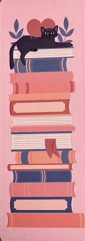 Bookmark featuring a cat atop a stack of books