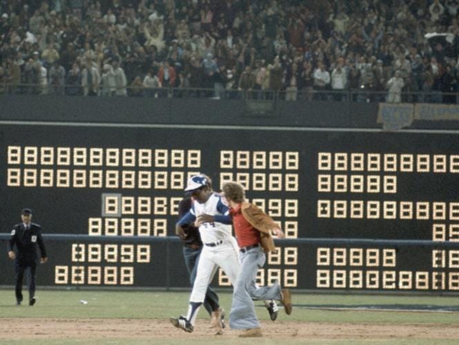 Two trespassing fans greet Hank Aaron as he rounds the bases following his historic 715th home run. Two trespassing fans greet Hank Aaron as he rounds the bases following his historic 715th home run.