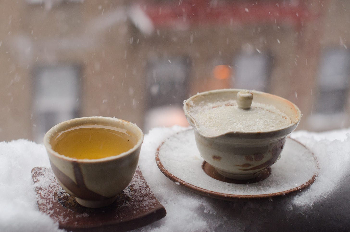 ID: Small teacup and pot on a snowy windowsill