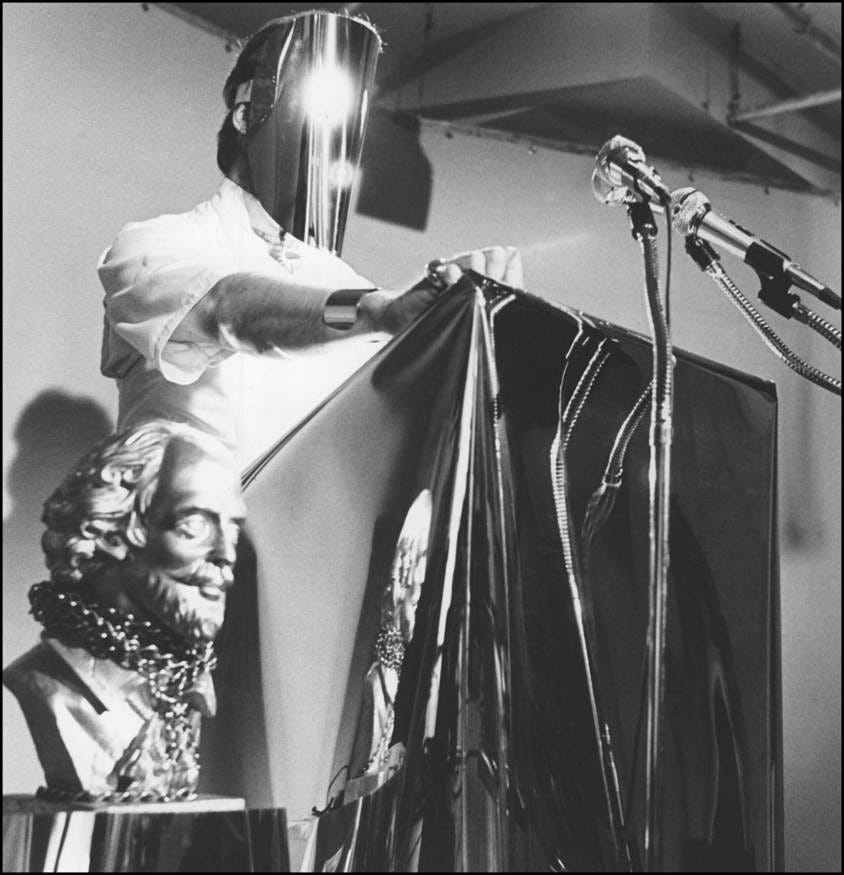 A person standing at a podium with a light on his head

AI-generated content may be incorrect.