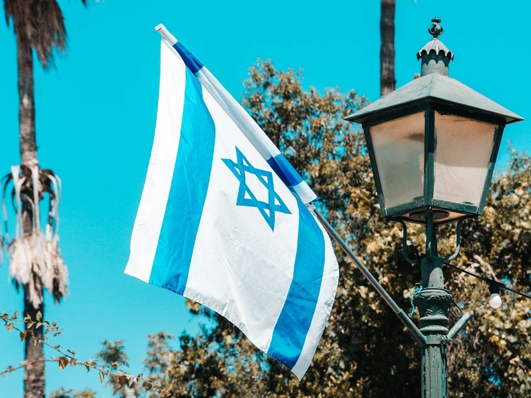 a lamp post with a flag hanging off of it's side
