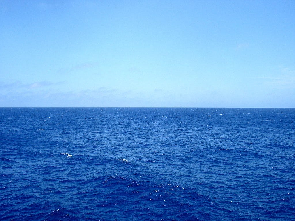 A calm open sea on a clear blue-sky day