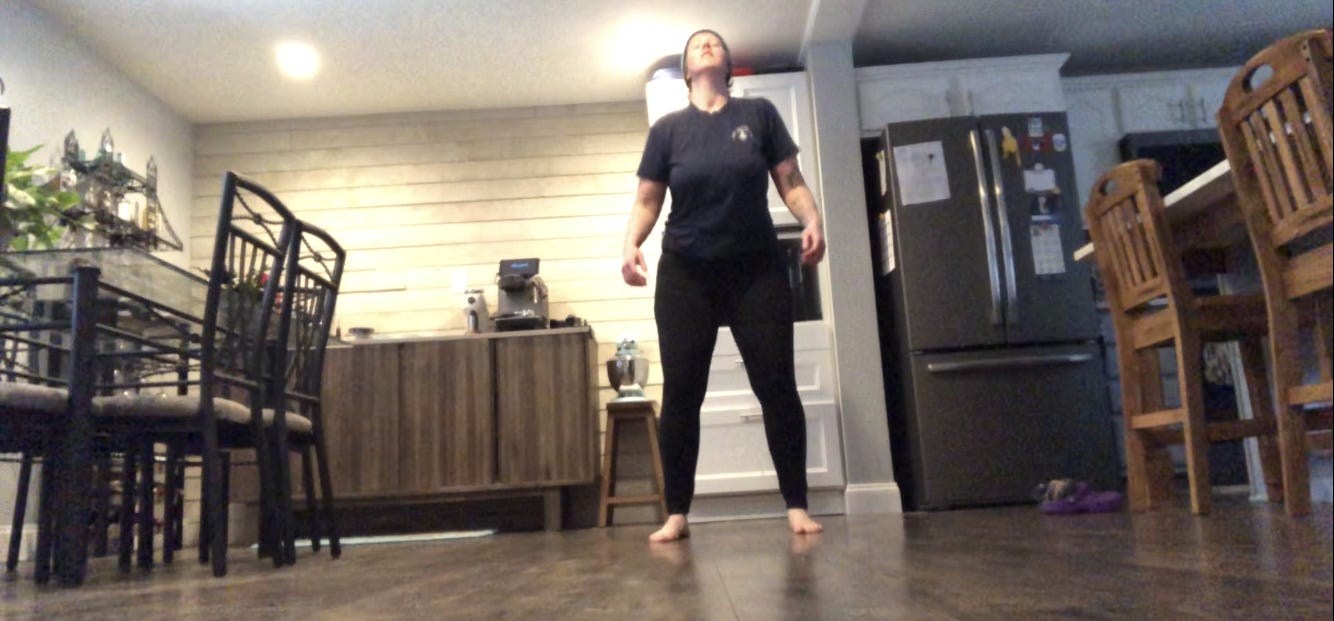 A person dances in a kitchen.