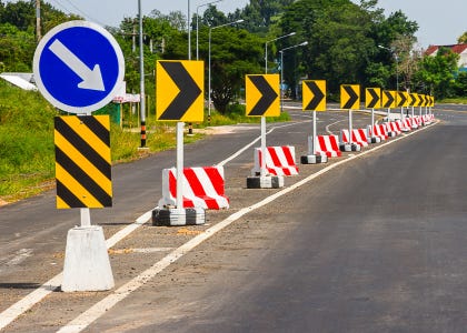 Many arrow signs indicating a lane closure on a road
