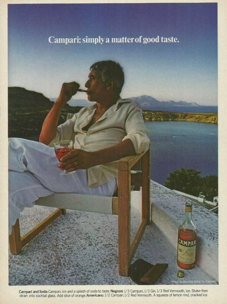 This may contain: an old man sitting in a chair drinking from a bottle and holding a glass with the caption campaign simply a matter of good taste