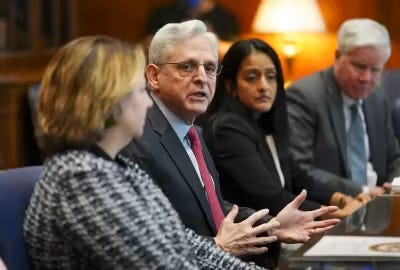 Attorney General Merrick Garland, with Associate Attorney General Vanita Gupta, who took primary responsibility for negotiating the settlement, seated to his left