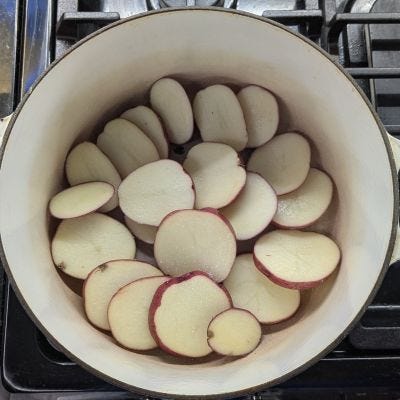 Picture of first potatoes, then onions, then carrots and meat in the pot