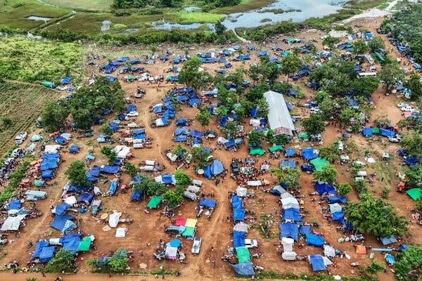 People huddling in and around tents in Oddar Meanchey Province in Cambodia. 