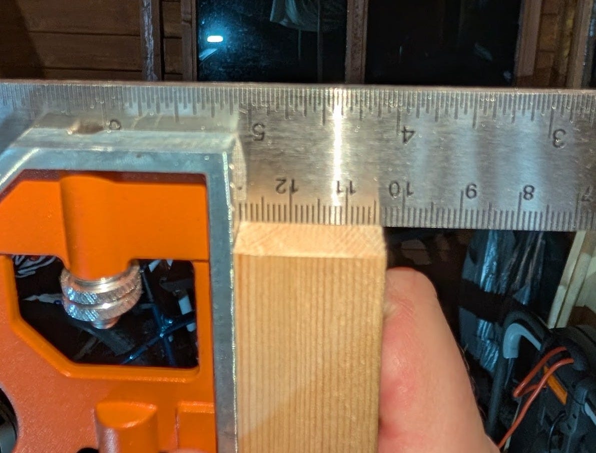 using a square to measure the accuracy of a cut end of lumber