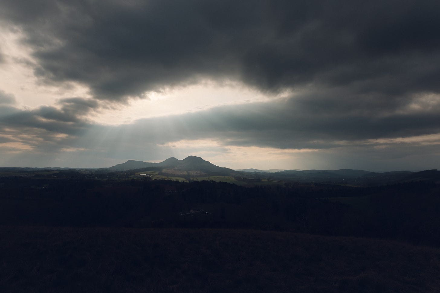 a view of hills with a dramatic sky above