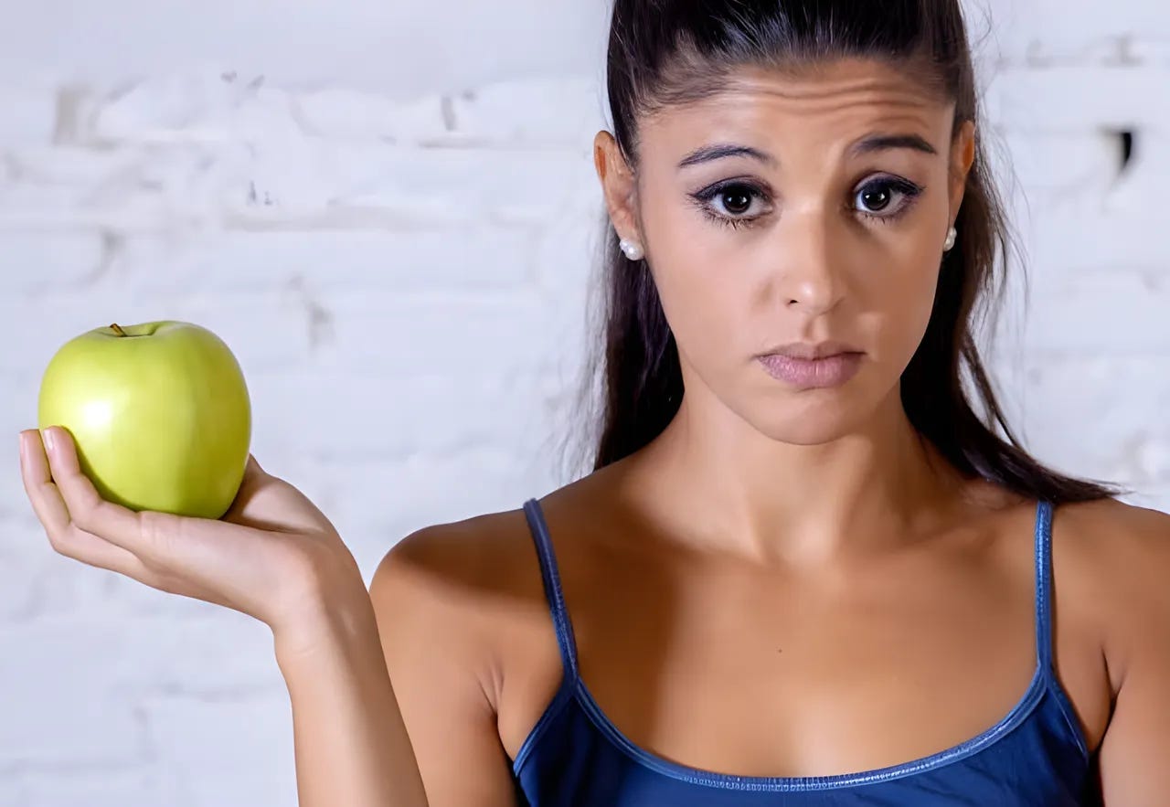 Woman holding an apple and looking skeptical. Woman holding an apple and looking skeptical.