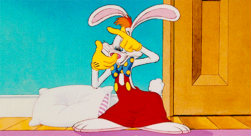 Gif dal film "Chi ha incastrato Roger Rabbit" con il coniglio Roger che è in una stanza con parete azzurra e una porta gialla, mentre si mette a contare qualcosa sulle dita e sorride.