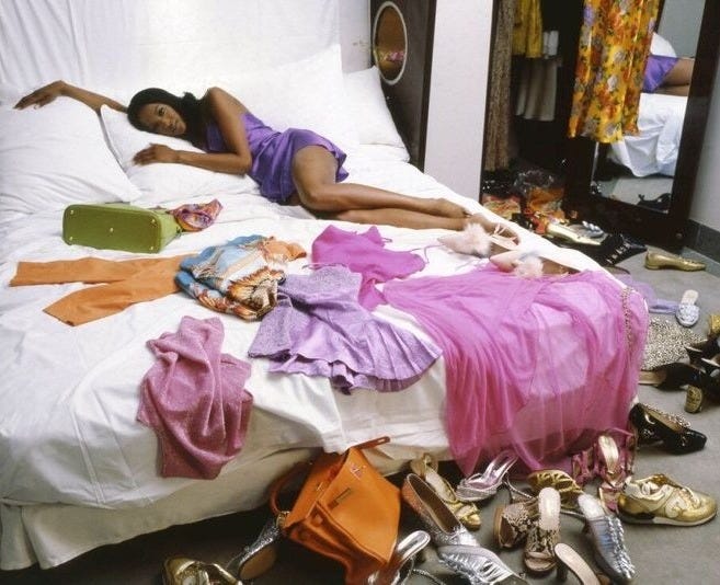 This may contain: a woman laying on top of a bed surrounded by shoes This may contain: a woman laying on top of a bed surrounded by shoes