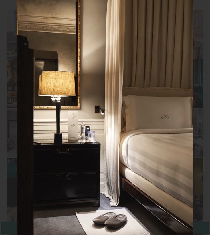 This may contain: a bedroom scene with focus on the bed and shoes in the foreground, along with a lamp