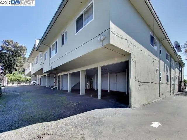 Rear view of the Eastlake Apartments property at 2515 10th Avenue showing unreinforced “soft story” apartment units over carports in 2017, before $1.1 million in repairs and seismic retrofitting were completed. Oakland, California. (Image source: Bay East Association of Realtors)