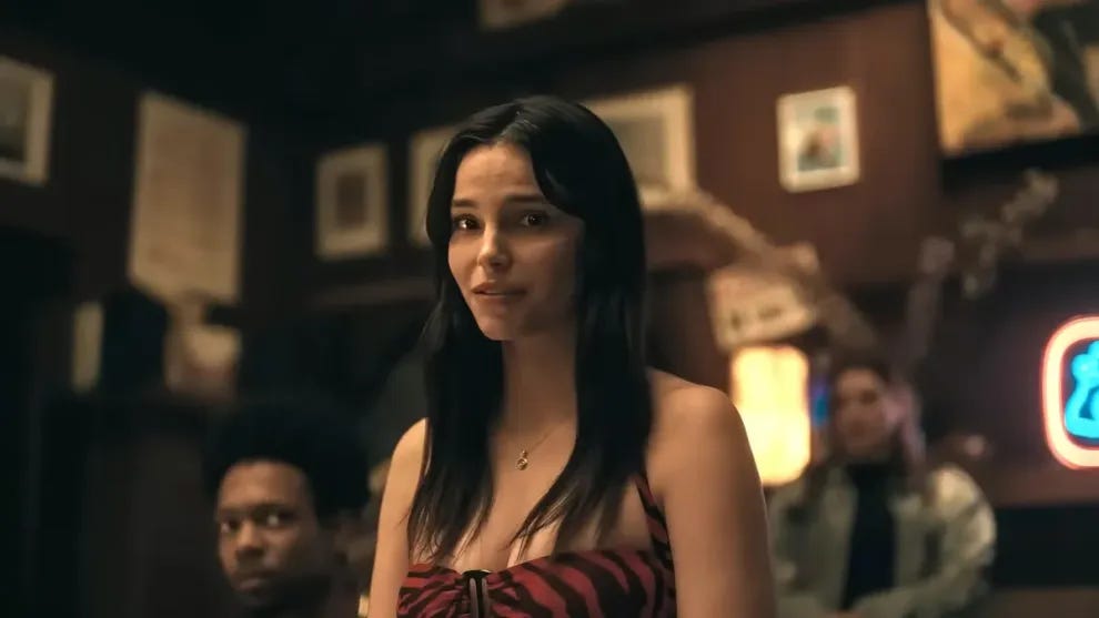 Nikki, white woman with long brown hair and lowcut dress looking longingly Nikki, white woman with long brown hair and lowcut dress looking longingly
