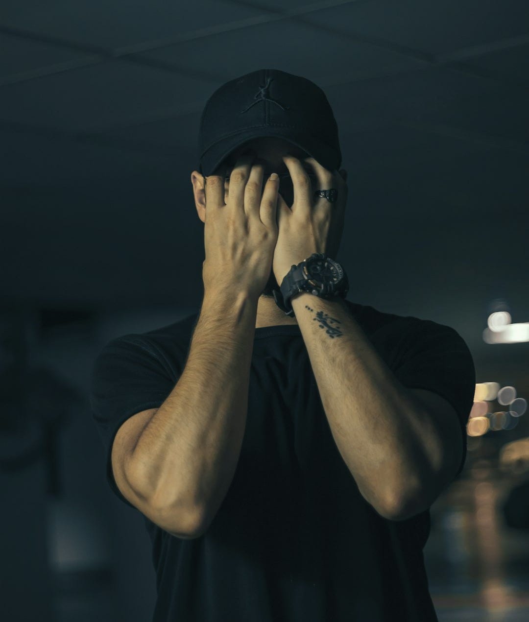 man in black crew neck t-shirt covering face with hands man in black crew neck t-shirt covering face with hands
