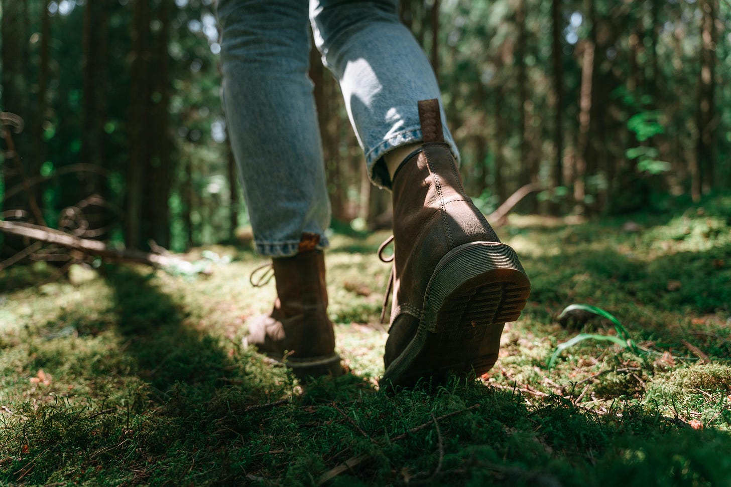 cropped image of a person hiking through a forest