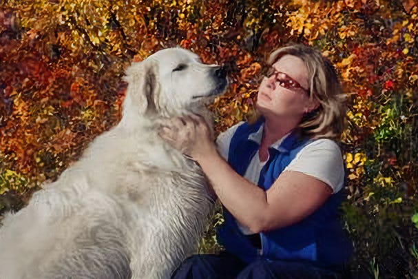 two different large whit dogs with woman in blue vest and woman in ball cap