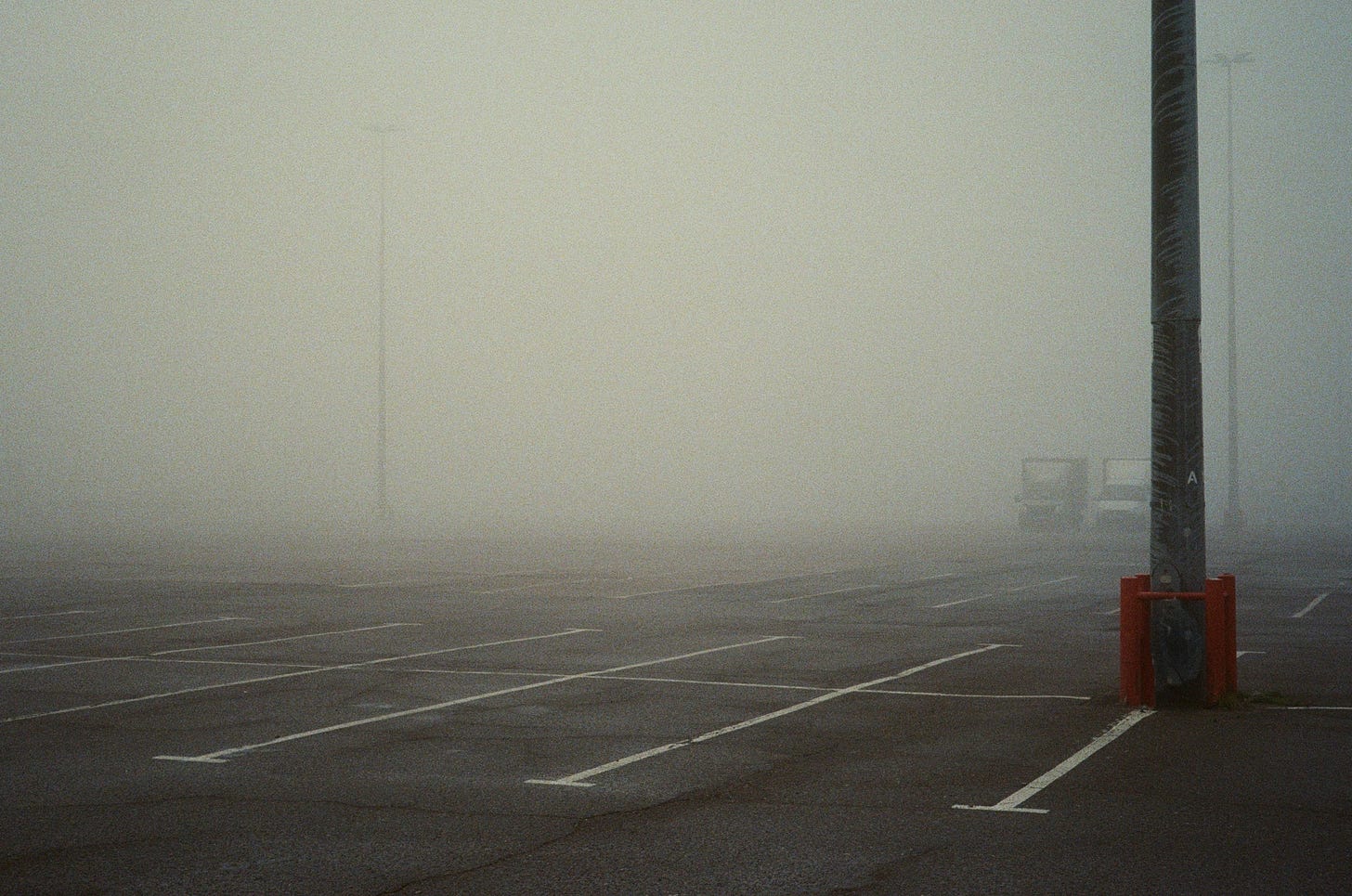 an empty parking lot covered in fog.