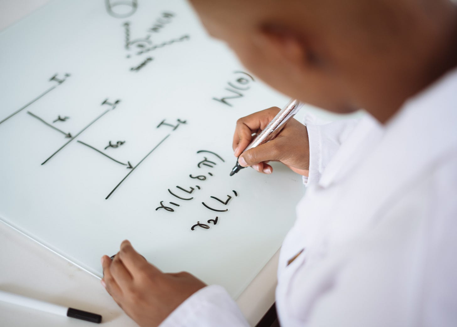 Photo Of Person Deriving Formula On White Board Photo Of Person Deriving Formula On White Board