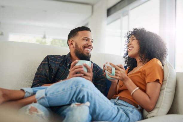 Never stop making time for each other Shot of a young couple enjoying a coffee break while relaxing together at home woman sitting in mans lap stock pictures, royalty-free photos & images