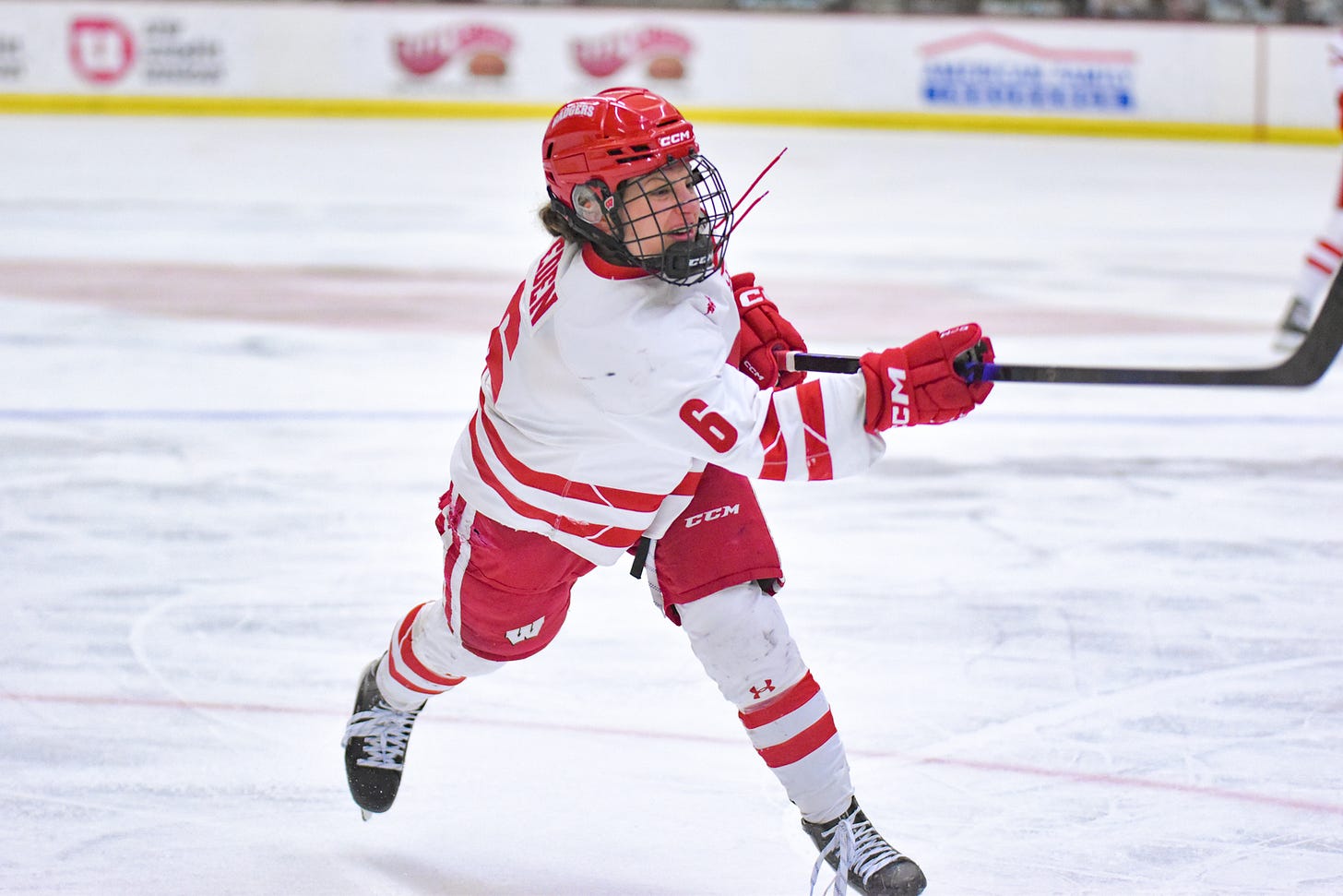 Lacey Eden shooting the puck toward the right of the camera Lacey Eden shooting the puck toward the right of the camera