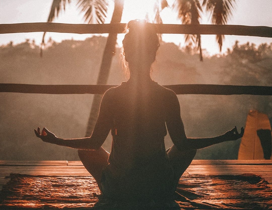 woman doing yoga meditation on brown parquet flooring