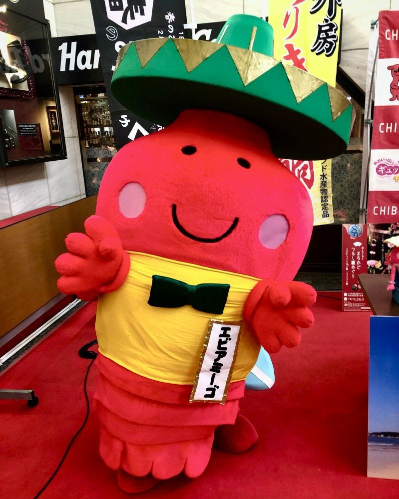 A red lobster mascot wearing a green sombrero