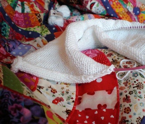 Knitting under a patchwork blanket Knitting under a patchwork blanket