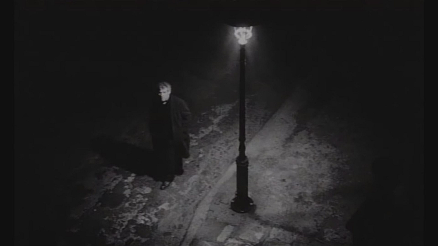Brown (János Derszi), standing under a streetlight that's providing the only illumination.