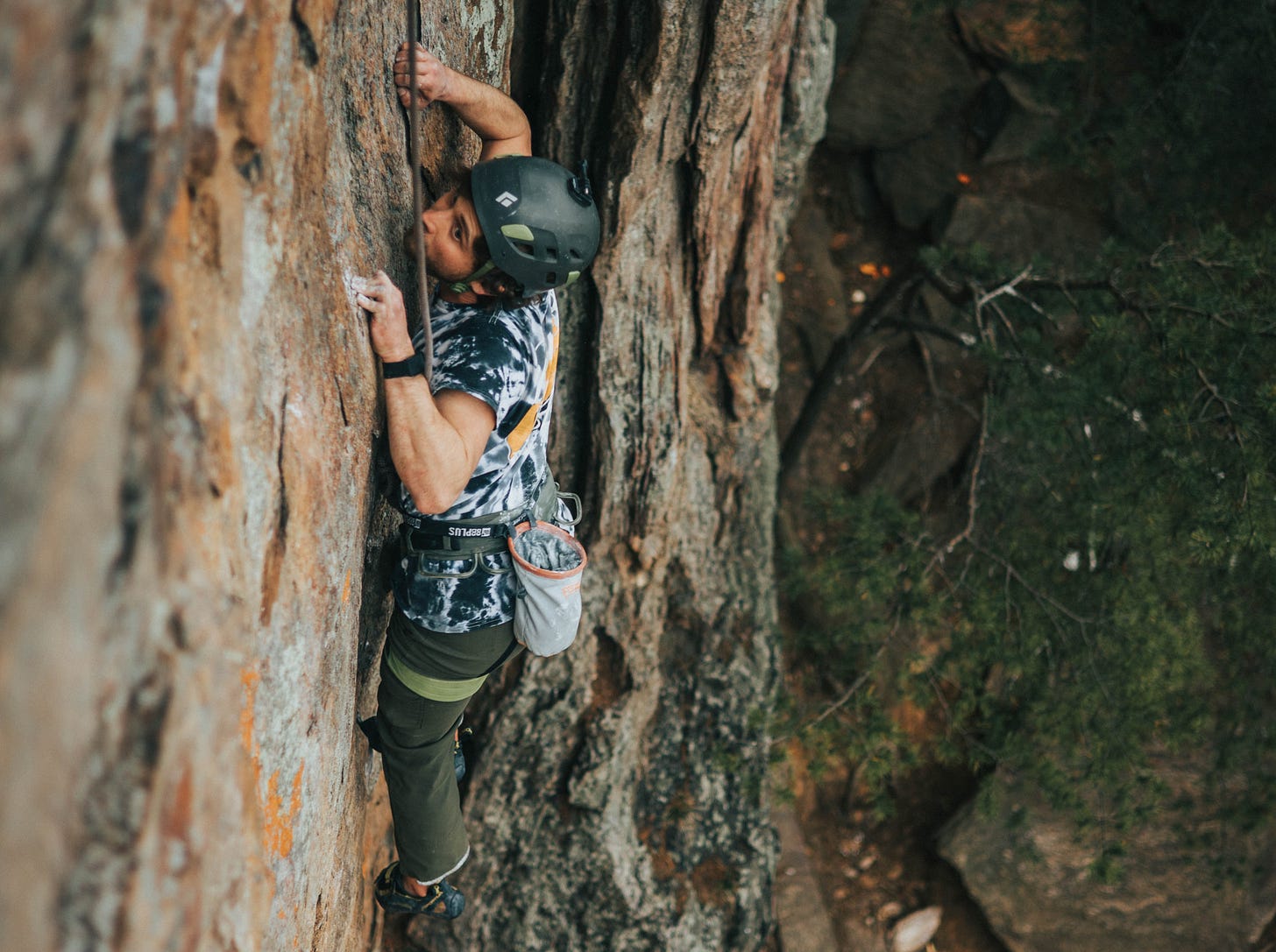 A young man in black helmet climbing on rock