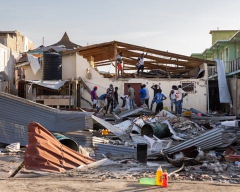 Men gather at a destroyed building