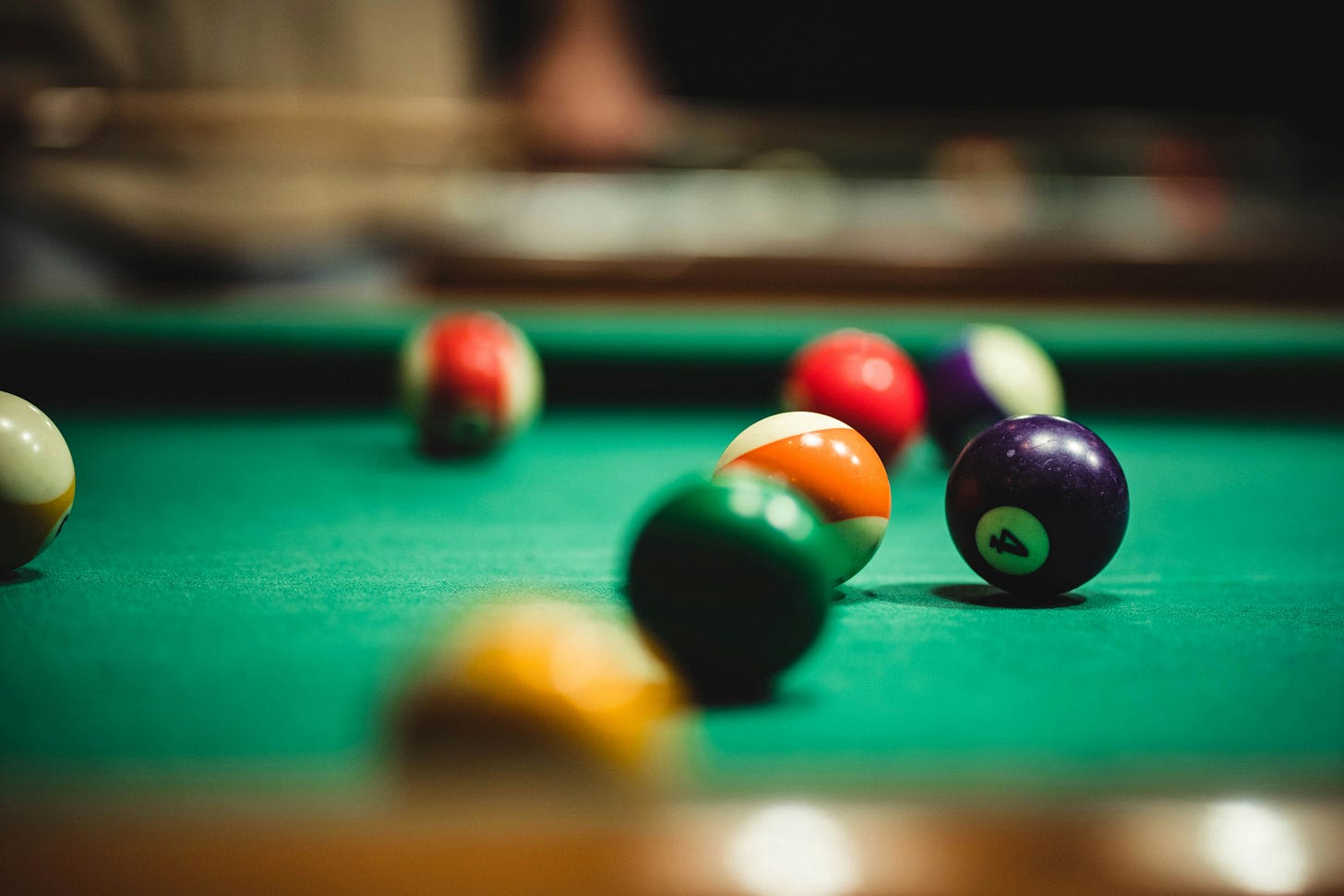 A pool table with eight balls present