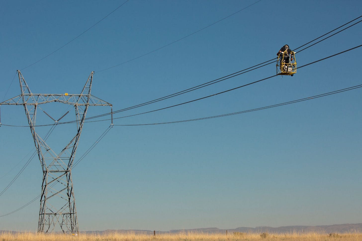 Worker repairing powerline running from Colorado to Wyoming 