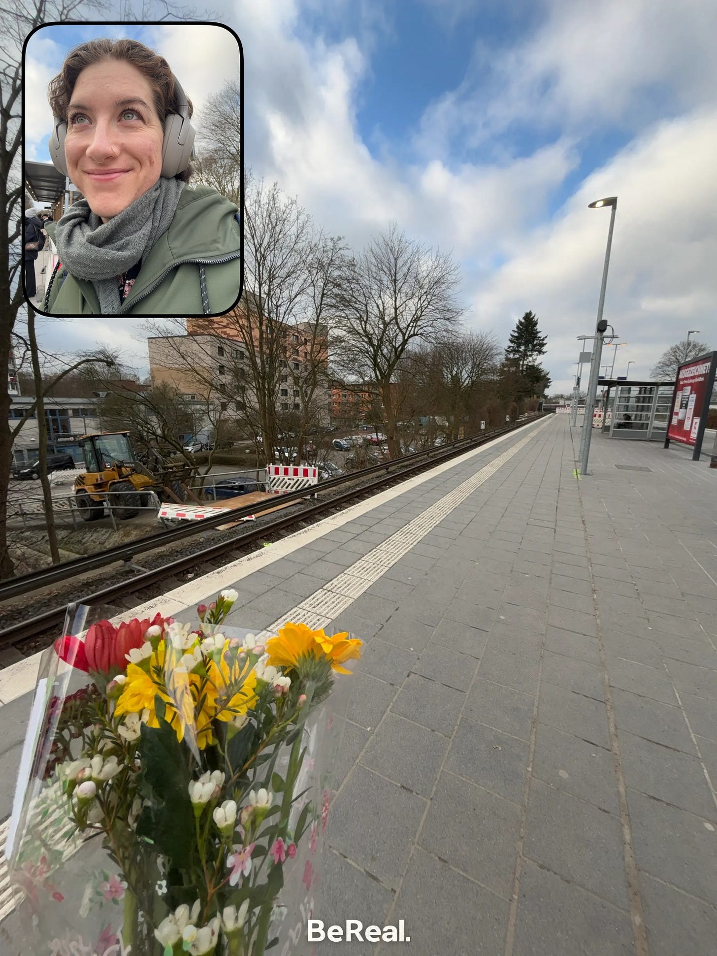 A BeReal of Maeve with a selfie and a picture of a bouquet of flowers, waiting at an SBahn station