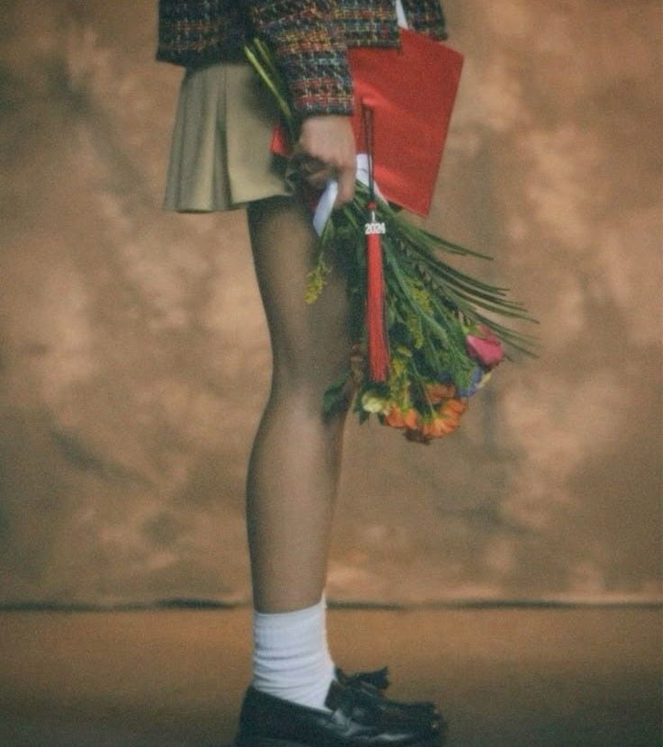 This may contain: a woman in short skirt holding flowers and umbrella