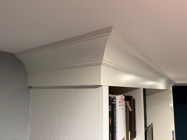 Two photos show a close-up of crown moulding around built-in bookcases.