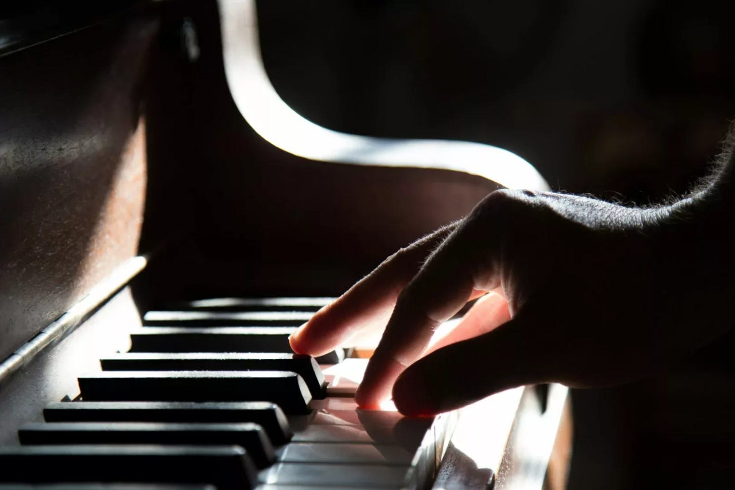 Steinway upright piano with fingers pressing keys