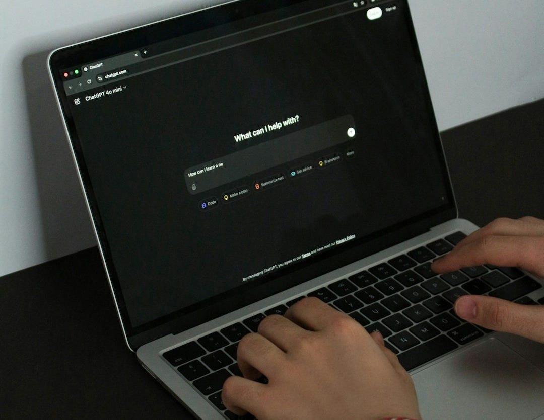 A person typing on a laptop on a table