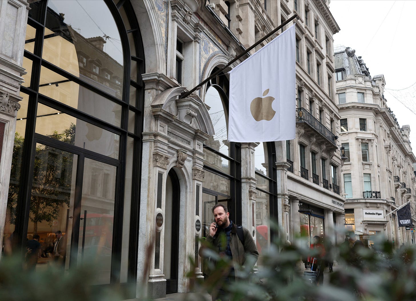 People walk past an Apple store in London