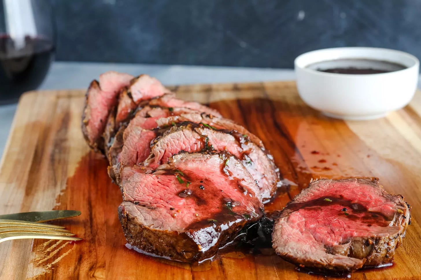 Medium-rare classic French chateaubriand sliced on a wooden cutting board
