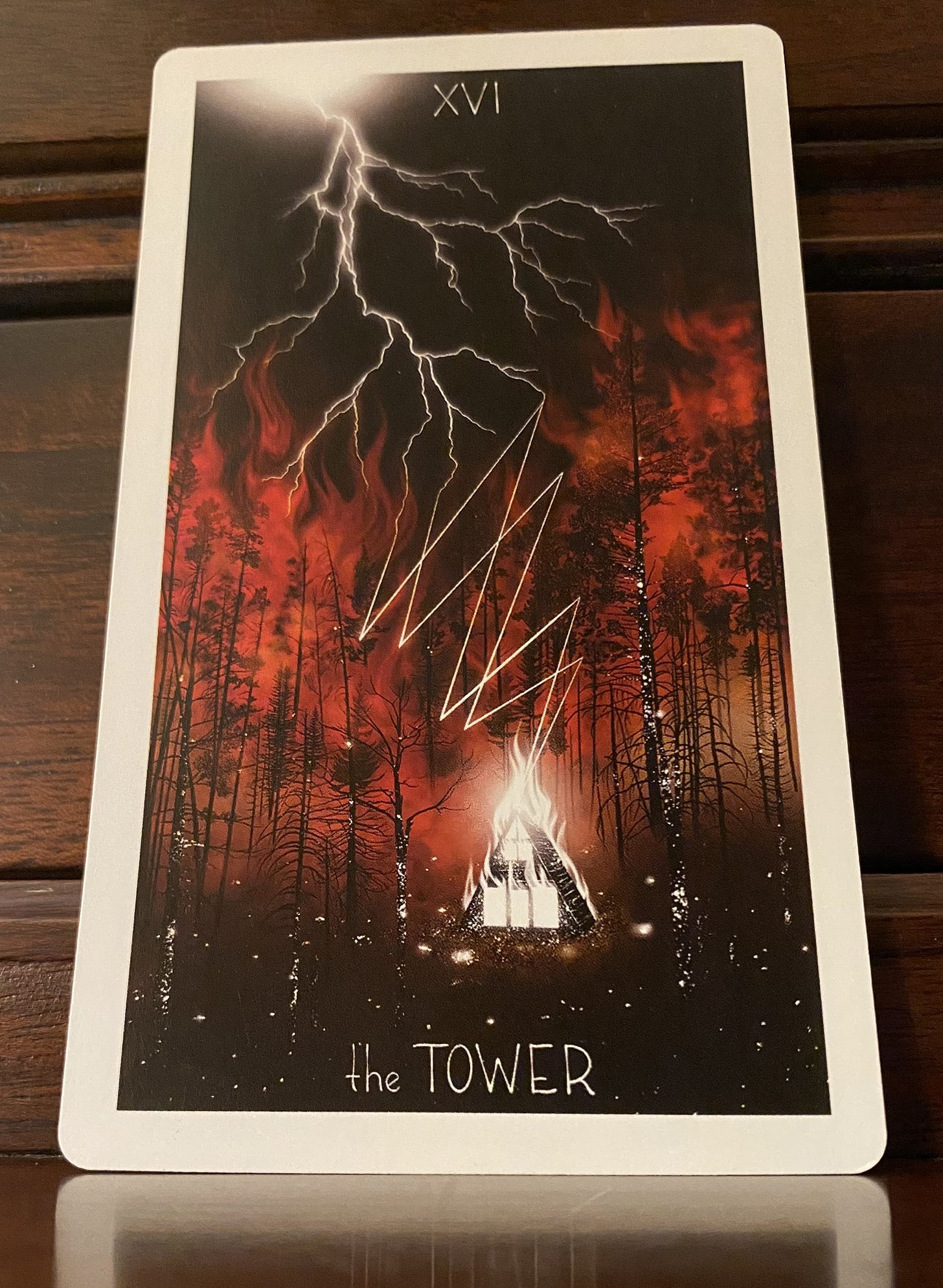 Tower tarot card with lighting hitting cabin in a burning forest