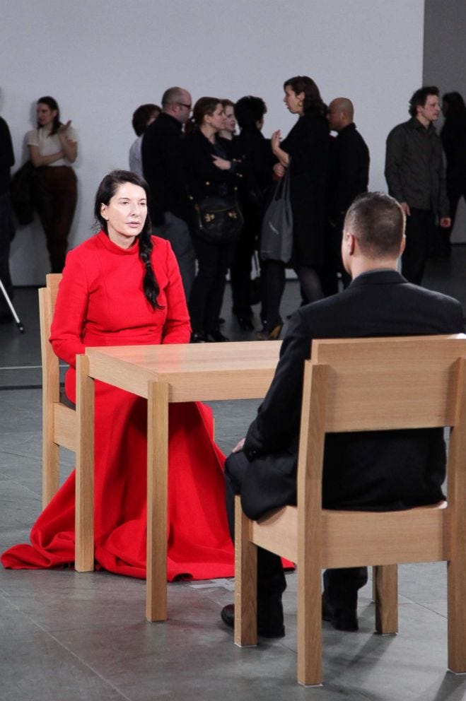 Many headshots, a woman in red with a long black braid sitting across from a man in a suit