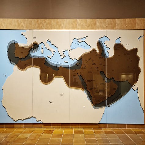 On the left, a map showing the maximum expansion of the Umayyad Caliphate, including Spain, Portugal and Cyprus; in the center, a museum sign explaining the period of unification of Saudi Arabia; on the right, the Riyadh Water Tower