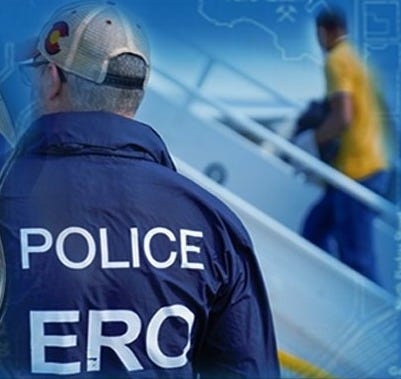 Immigration & Customs Enforcement (ICE) Agent assigned to Enforcement & Removal Operations (ERO) guards aircraft boarded by a migrant being deported from the US