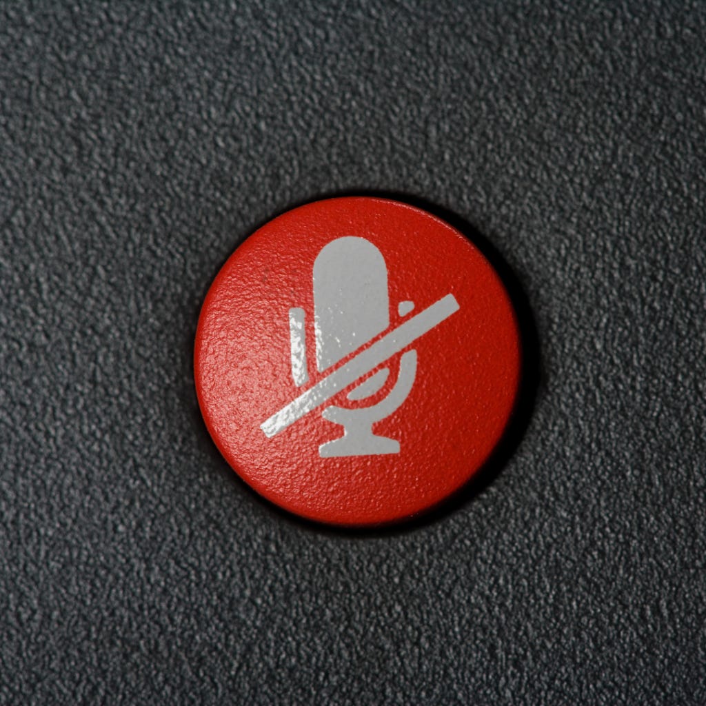 A photo of a red, muted microphone button.
