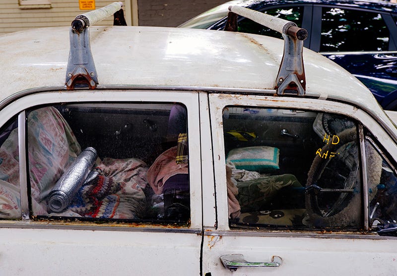 the inside of the car. old rugs and worn seats 