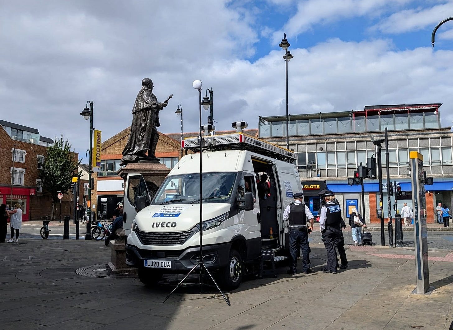 May be an image of 9 people, ambulance, street and text